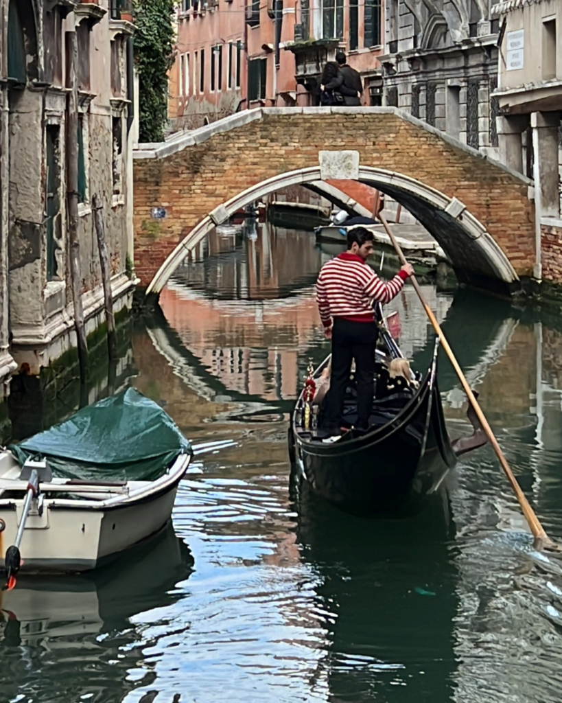 A gondolier transporting passengers in Venice