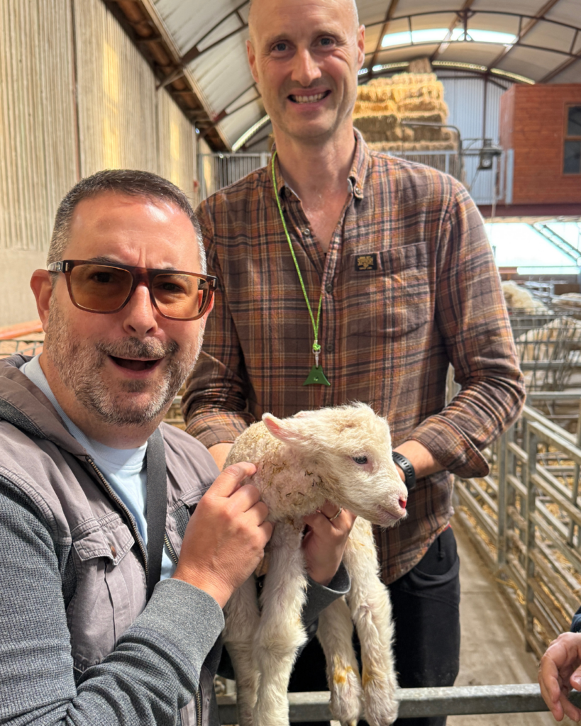 Josh Scheer holding a newborn lamb at Glenshane Country Farm with shepherd Jamese McCloy, Sperrin Mountains, Northern Ireland